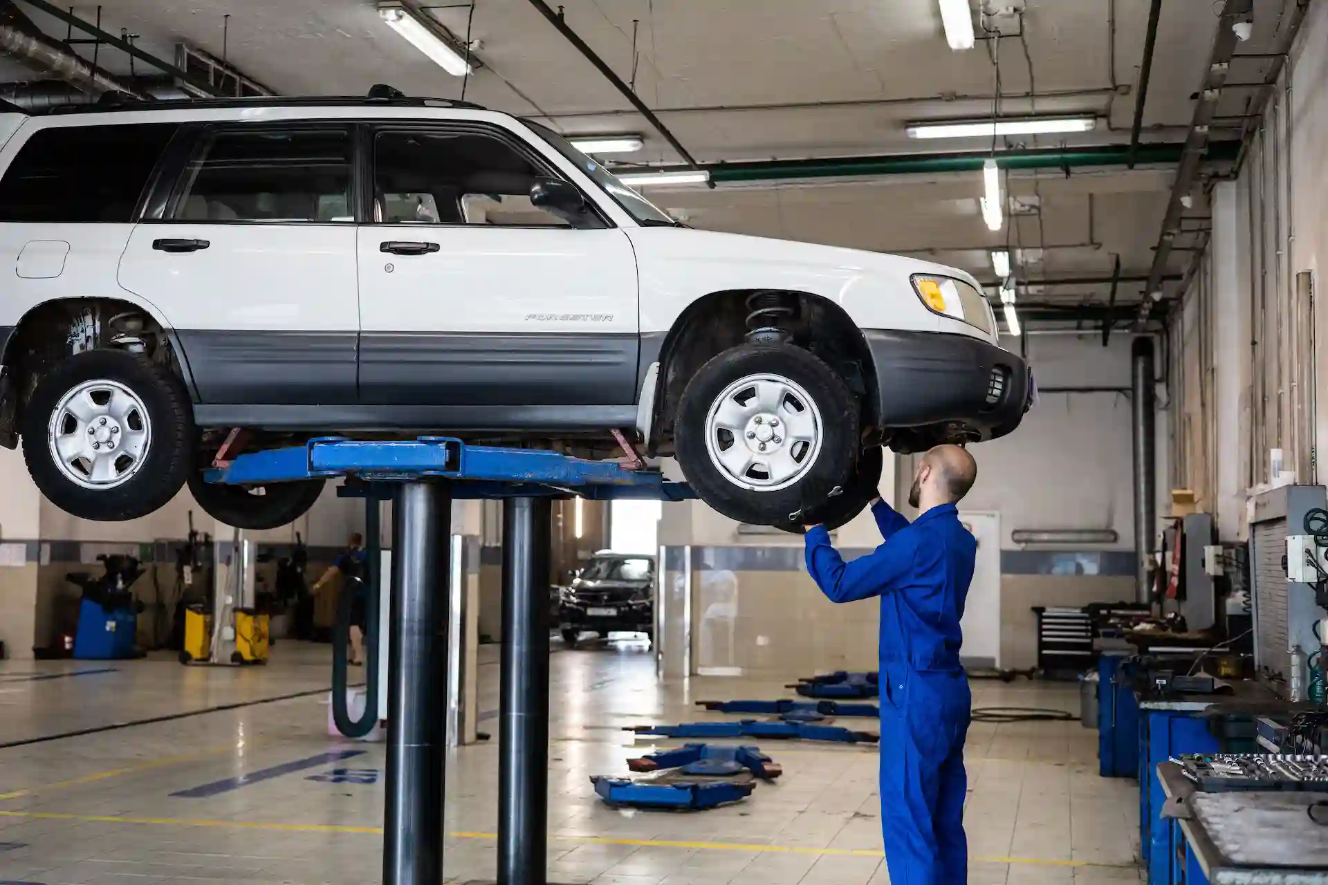 Mecánico revisando un auto elevado en un taller